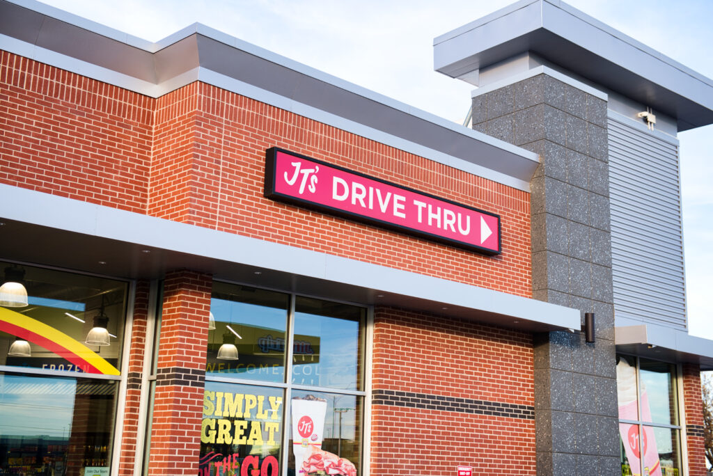 Jiffy Trip Drive Thru sign against a brick facade, showcasing the convenience of on-the-go service.